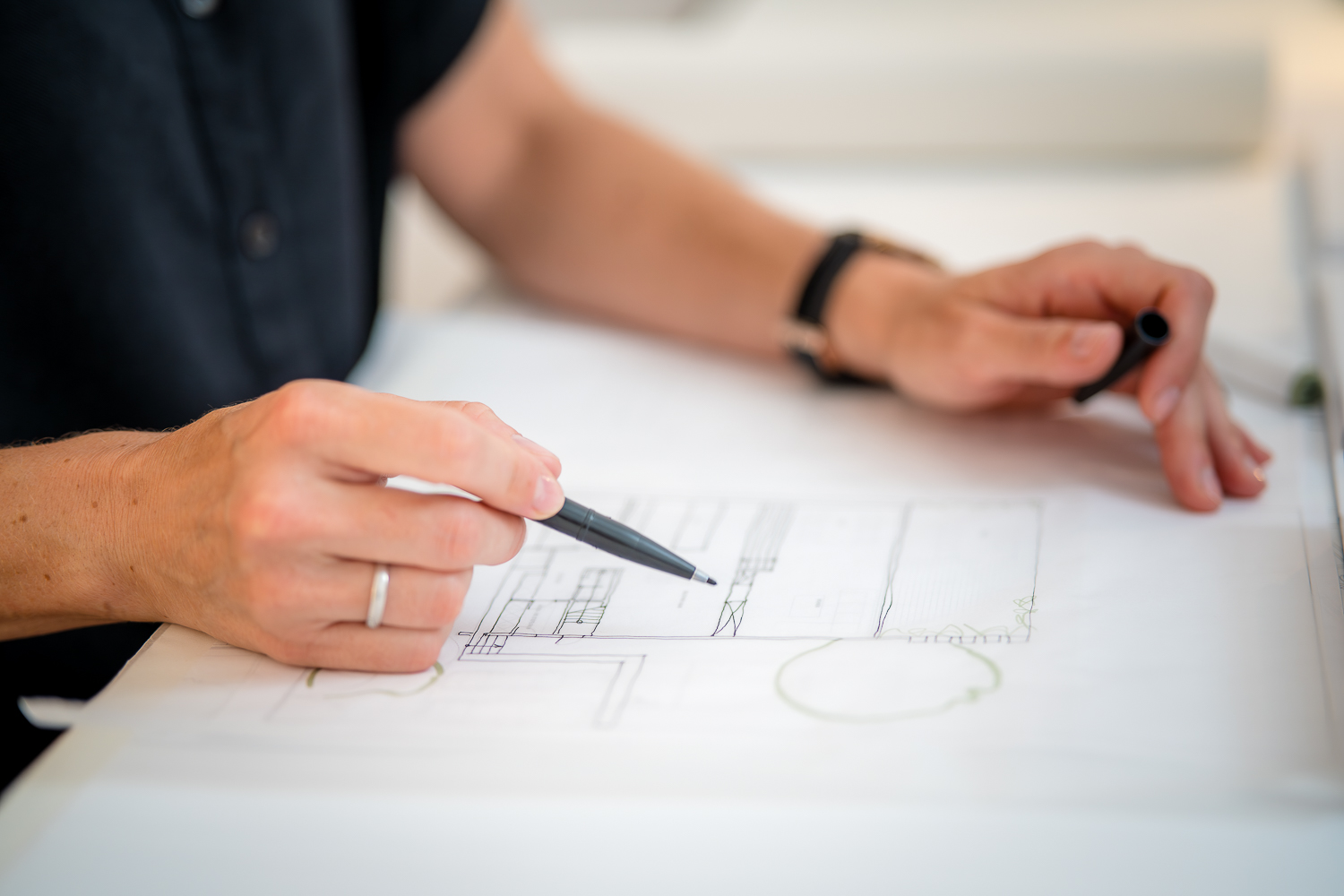 Detailbild Hände der Architektin Jacqueline Preßmann bei der Entwicklung eines Architekturentwurfs mit Skizzen und Stift