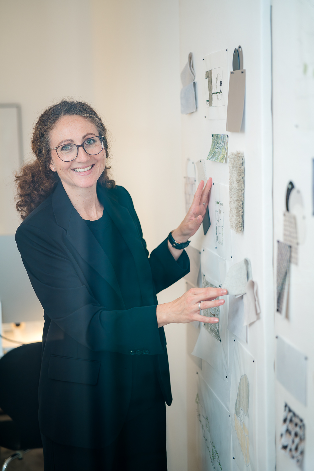 Architektin Jacqueline Preßmann entwickelt Material- und Entwurfskonzepte für ein Projekt anhand von Materialmustern und Entwurfsskizzen an einer Pinnwand